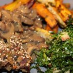 Mandelsteg med champignonsauce serveret med bagte rodfrugter og grønkålssalat