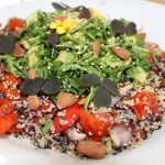 Farvet quinoa med bagte grøntsager, rucolatopping og mandler